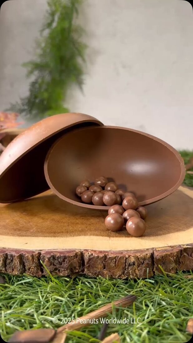 Ovo de chocolate Cacau Show com confeitos sobre tábua de madeira